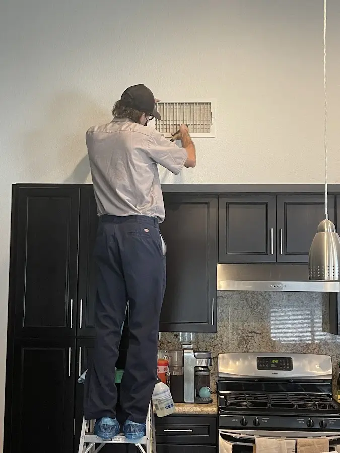 Technician inspecting an air vent during HVAC service in Lawrenceville